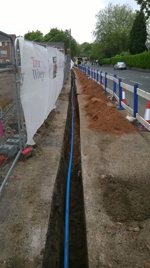 Water pipes laid in a trench beside a highway