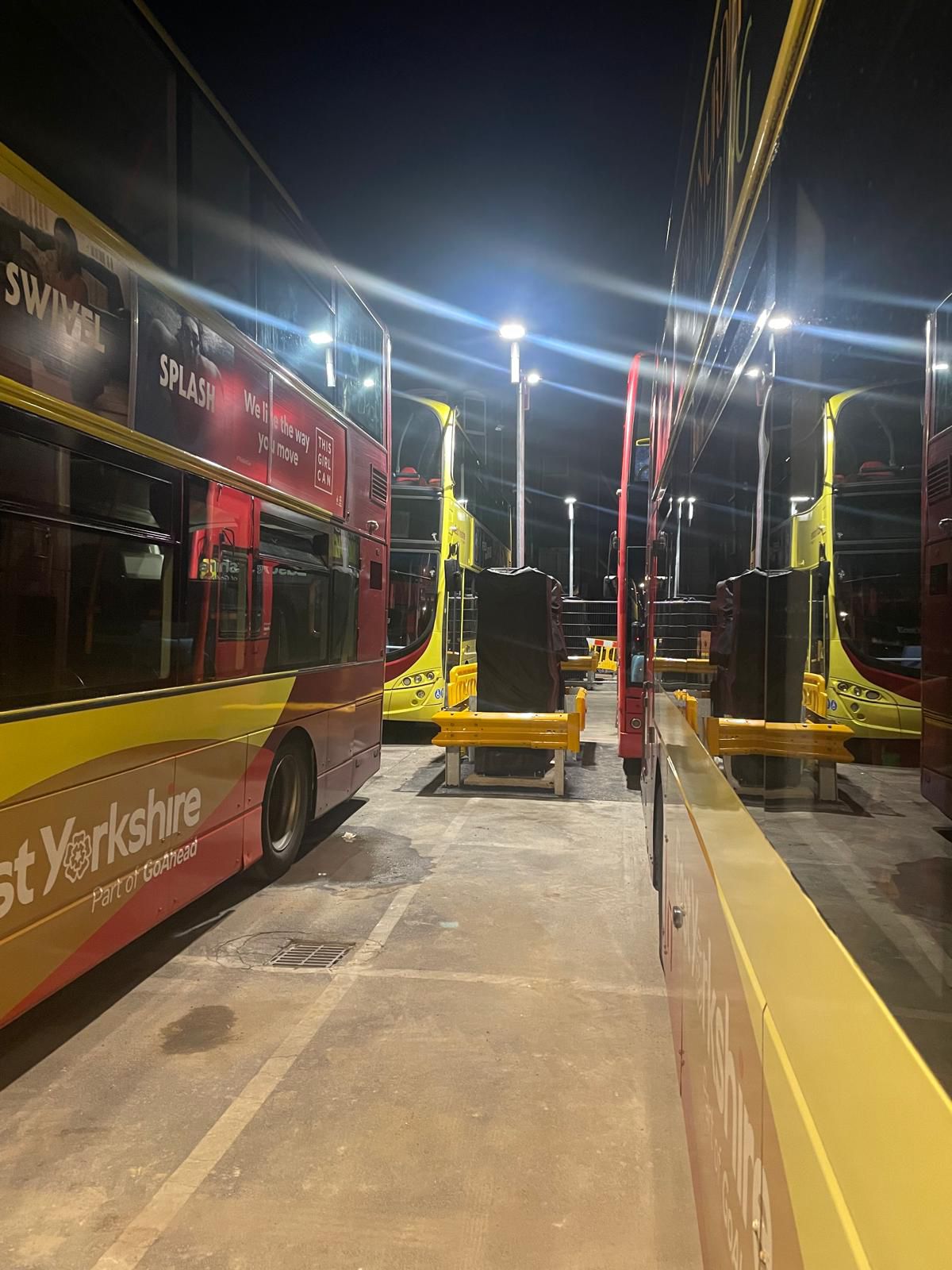 Buses parked in a depot at night