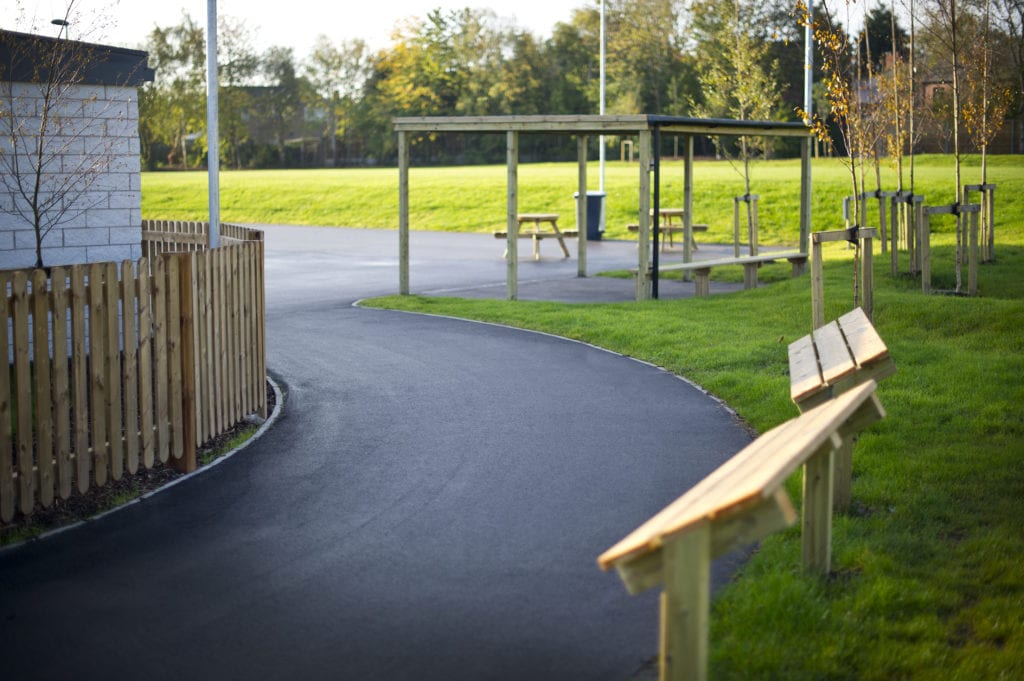 A paved footpath with street furniture outside a building