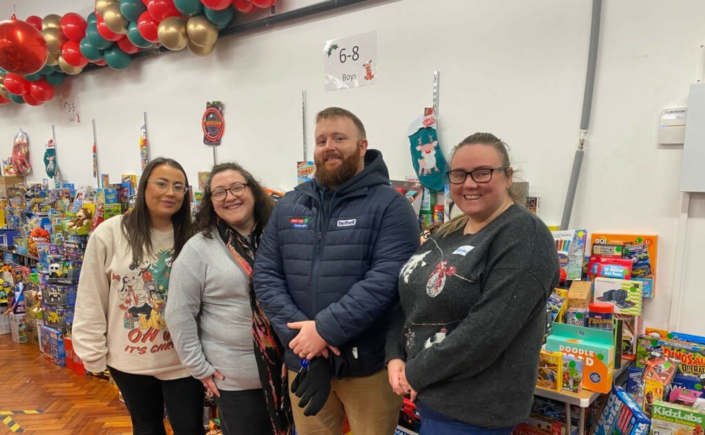 A group of volunteers at a distribution centre, handing out gifts for Christmas