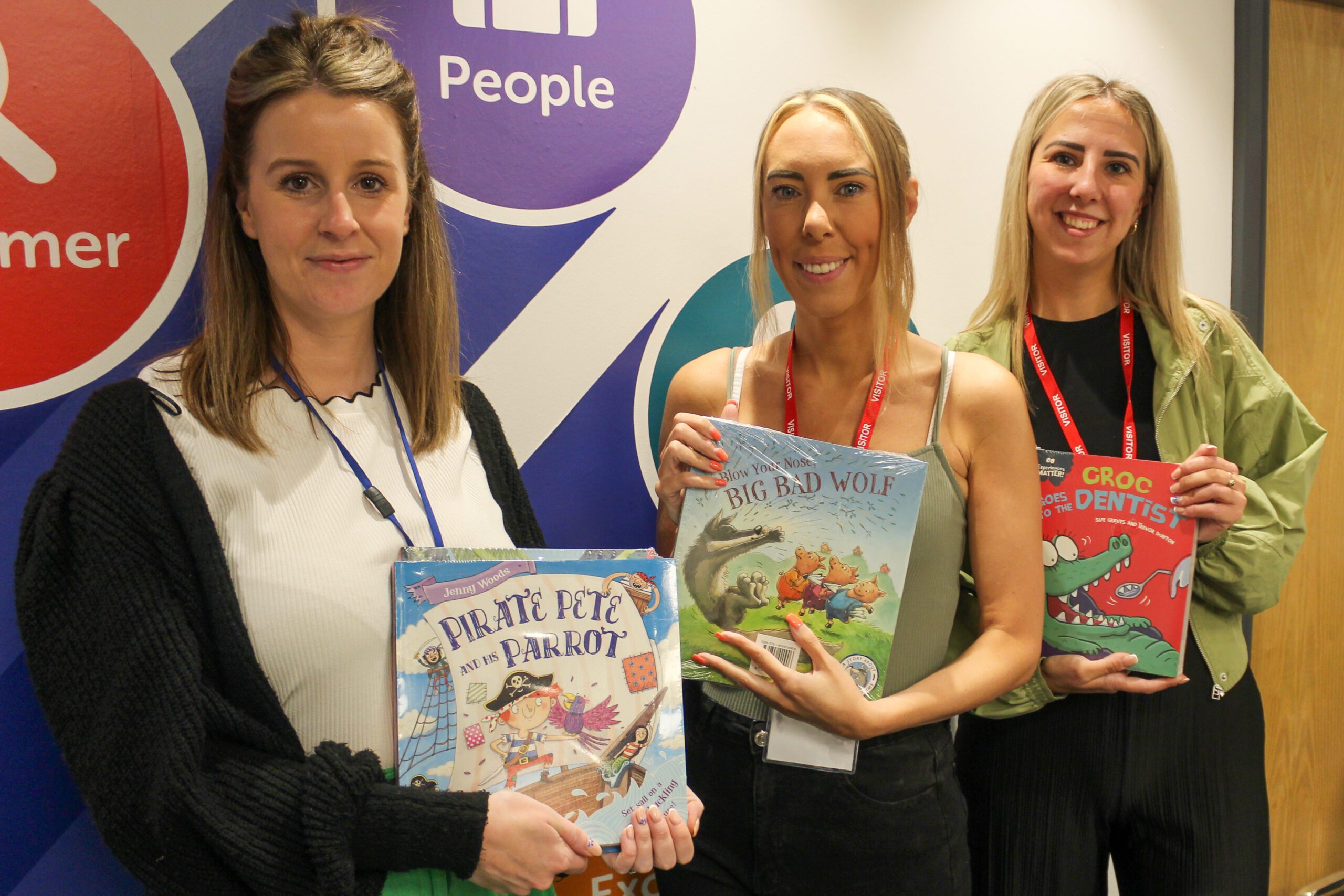 A group of people holding childrens books