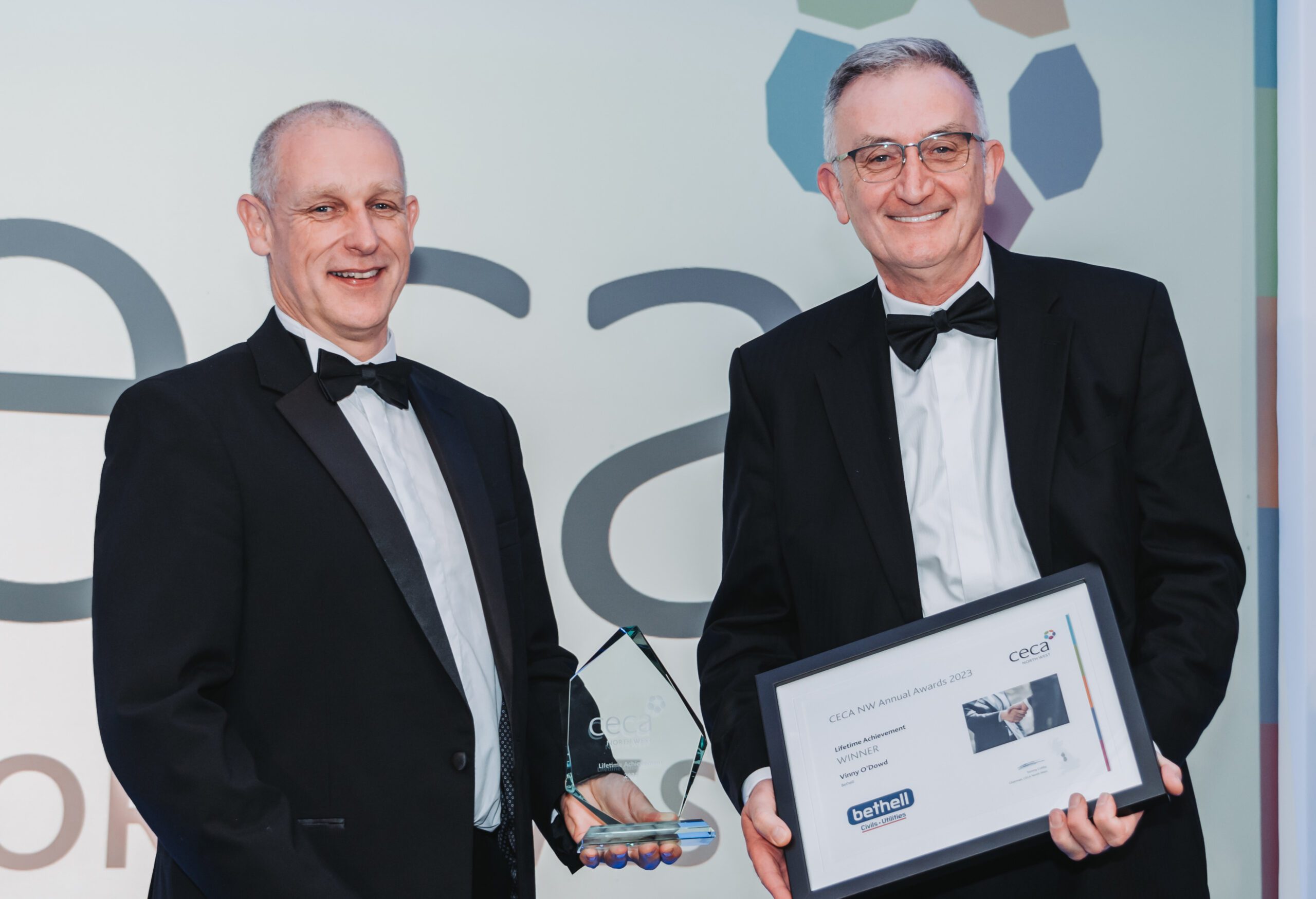 Person accepting award and trophy at industry awards ceremony
