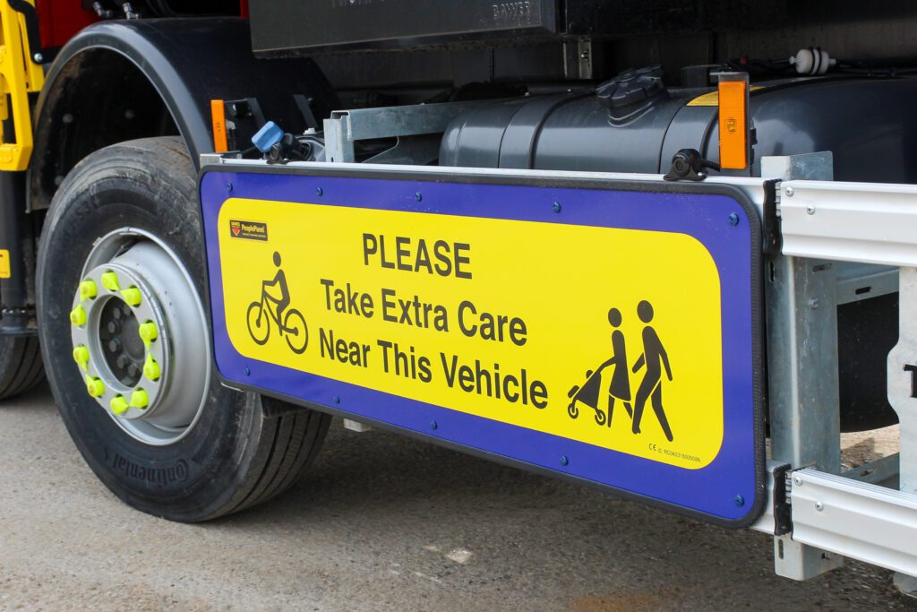 A sign on the side of a truck that reads "Please Take Extra Care Near This Vehicle"