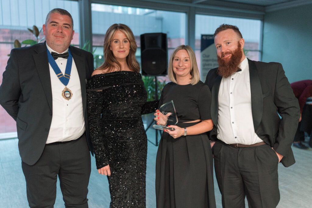 A group accepting an trophy at an industry award ceremony