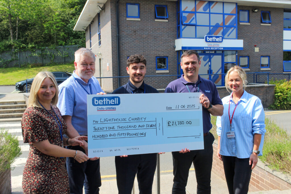 A group holding a cheque outside Bethell offices